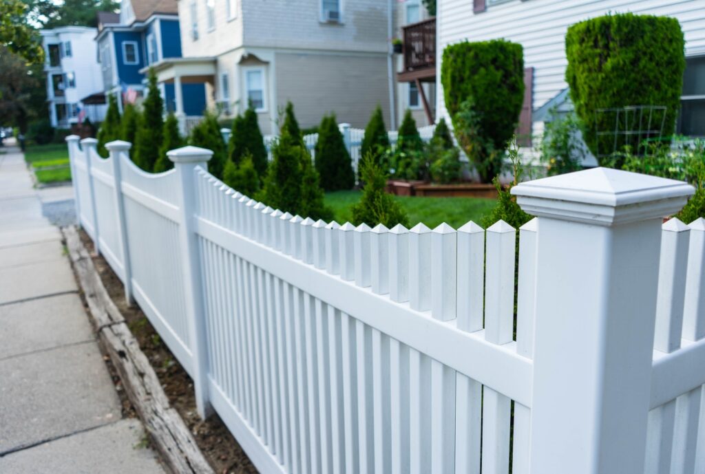 Front yard with a white picket fence enhancing curb appeal in a residential neighborhood.