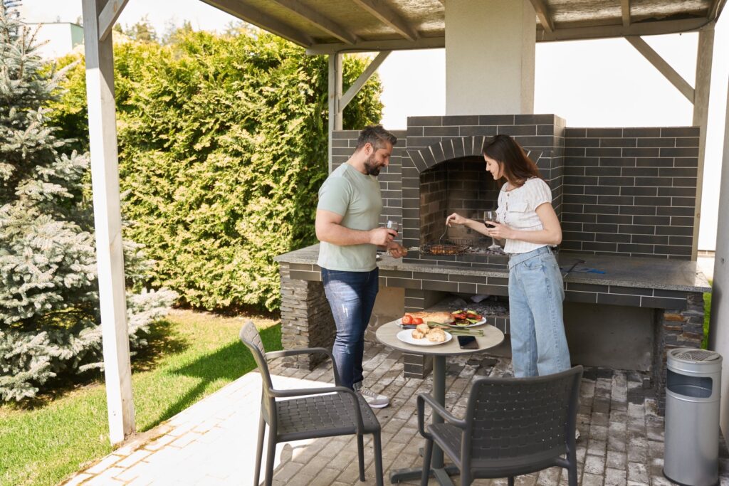 Homeowners enjoying a landscaped patio with paver flooring and garden border.