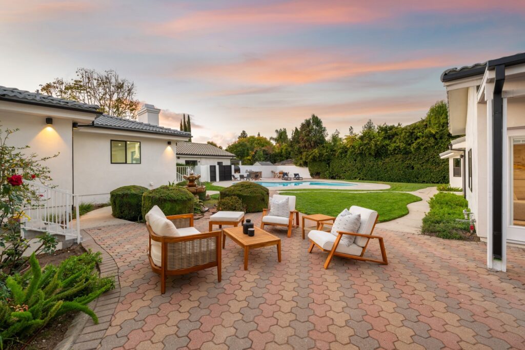 Completed paver patio with seating and landscaping accents.